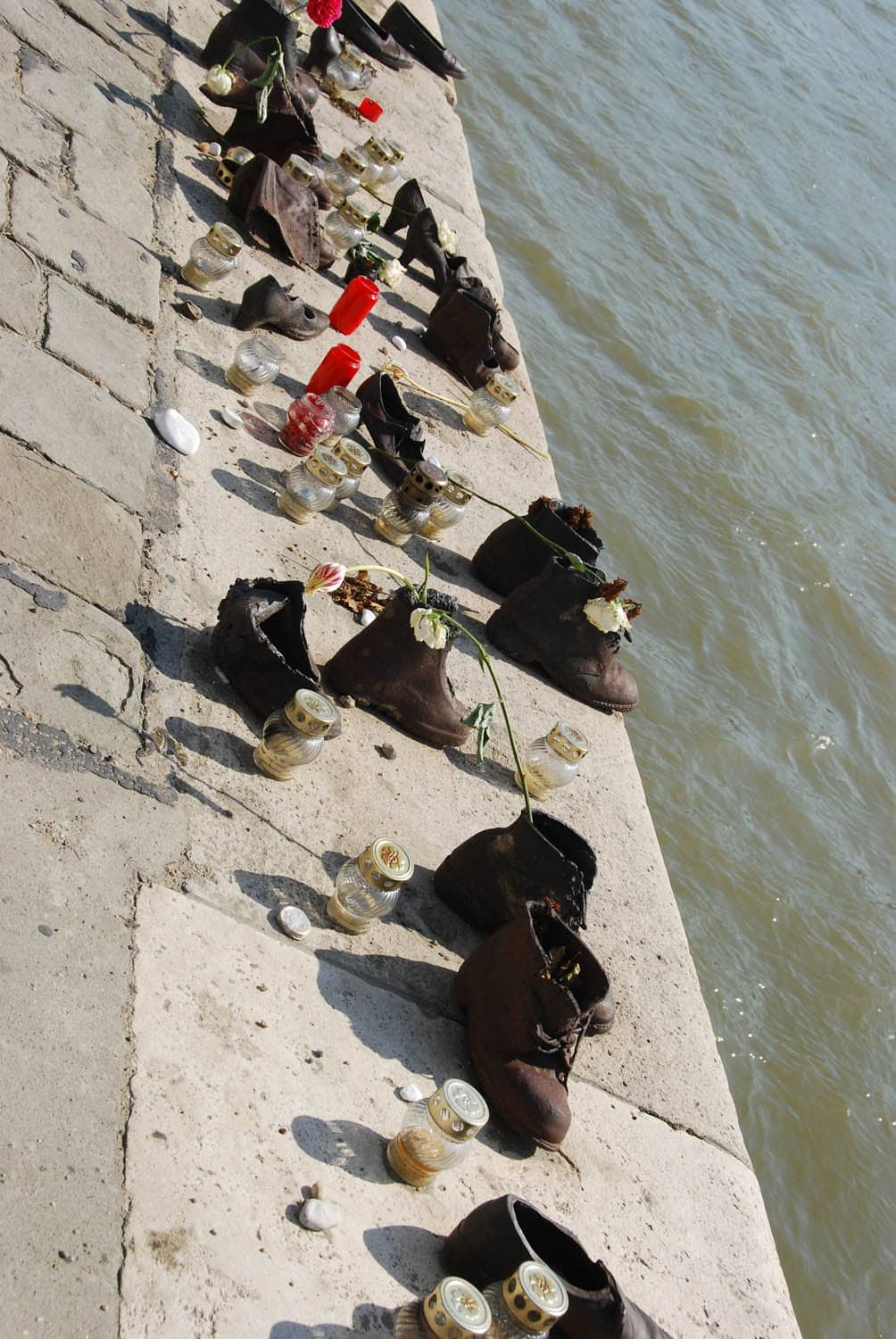 Chaussures, fleurs, bougies en hommage au bord du Danube