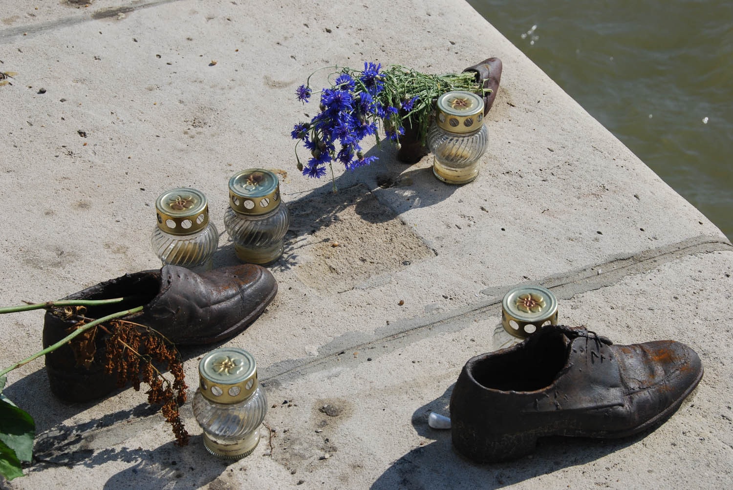 Chaussures, fleurs et bougies en hommage